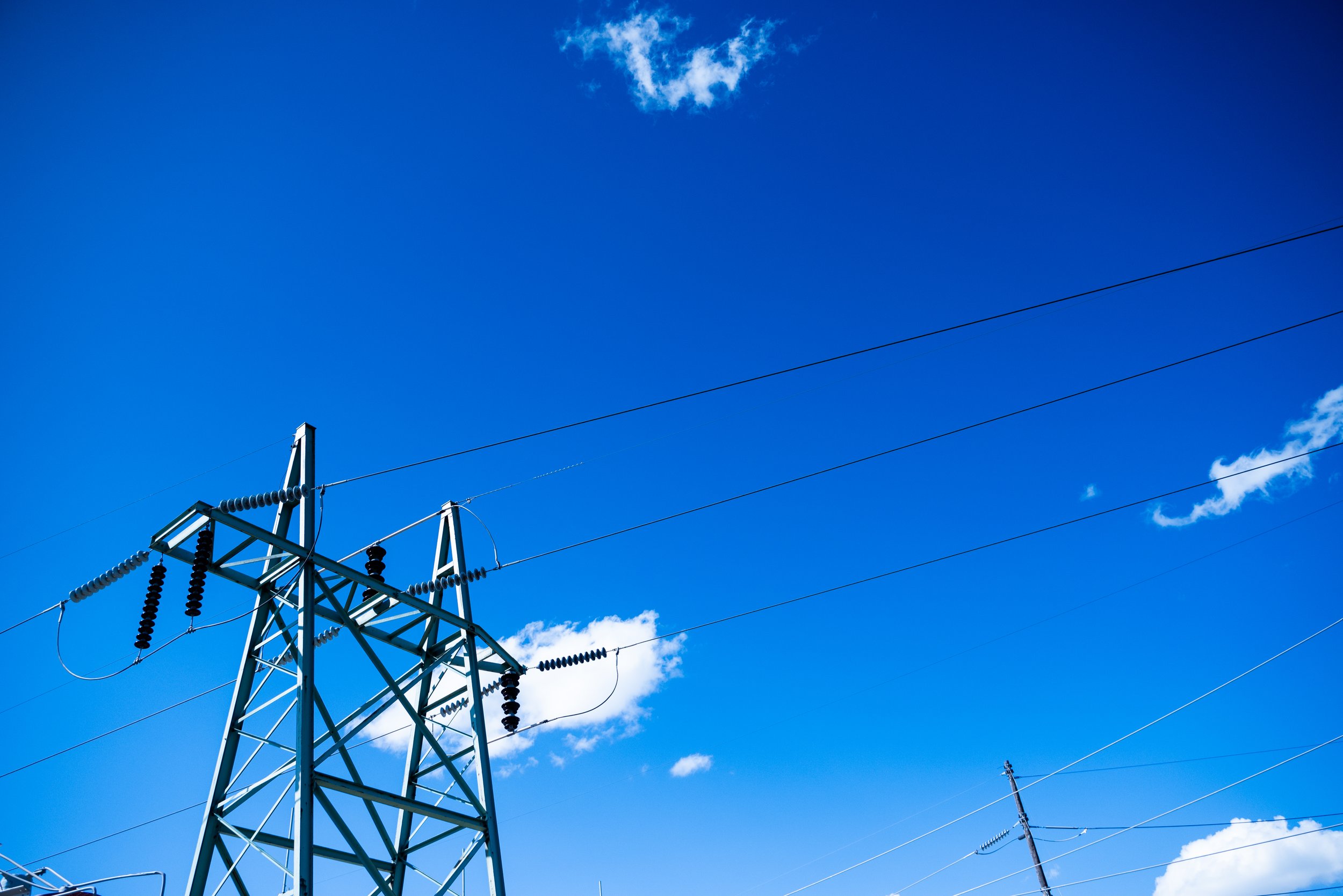 Electricity transmission tower against blue sky